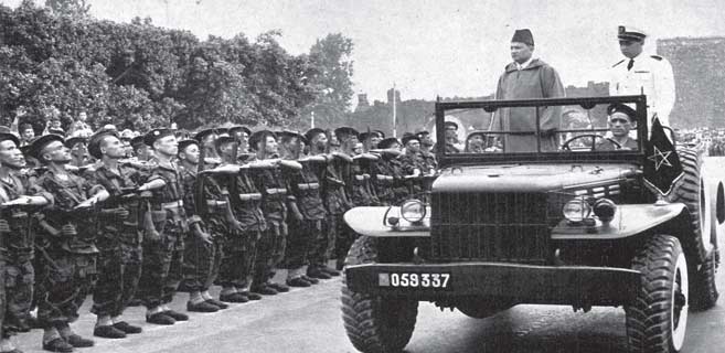 Feu Mohammed V passant en revue les premiers éléments des FAR, le 15 mai 1956 à Rabat, en compagnie du Prince héritier Moulay El Hassan, futur Hassan II.