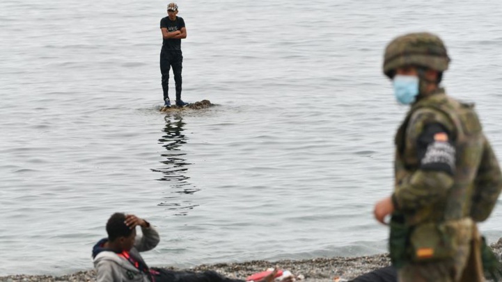Des migrants font face à un soldat espagnol après leur arrivée par la mer à Sebta (Ph. AFP).