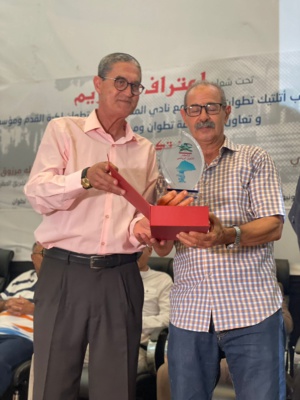 Samadi, doyen des journalistes tangérois, remettant l'emblème de la presse sportive de Tanger à Klaloussi.