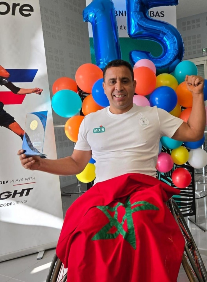 Lhaj brandissant, fièrement, les couleurs nationales et son trophée. Lhaj brandissant, fièrement, les couleurs nationales et son trophée.