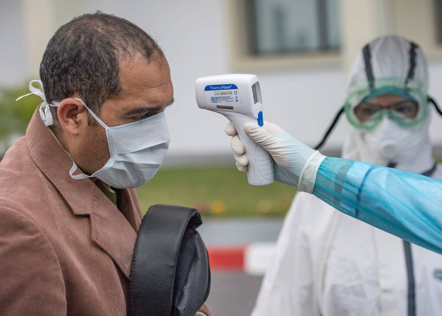Un agent de santé prend la température d'un patient à l'hôpital militaire Mohamed V de Rabat. © AFP