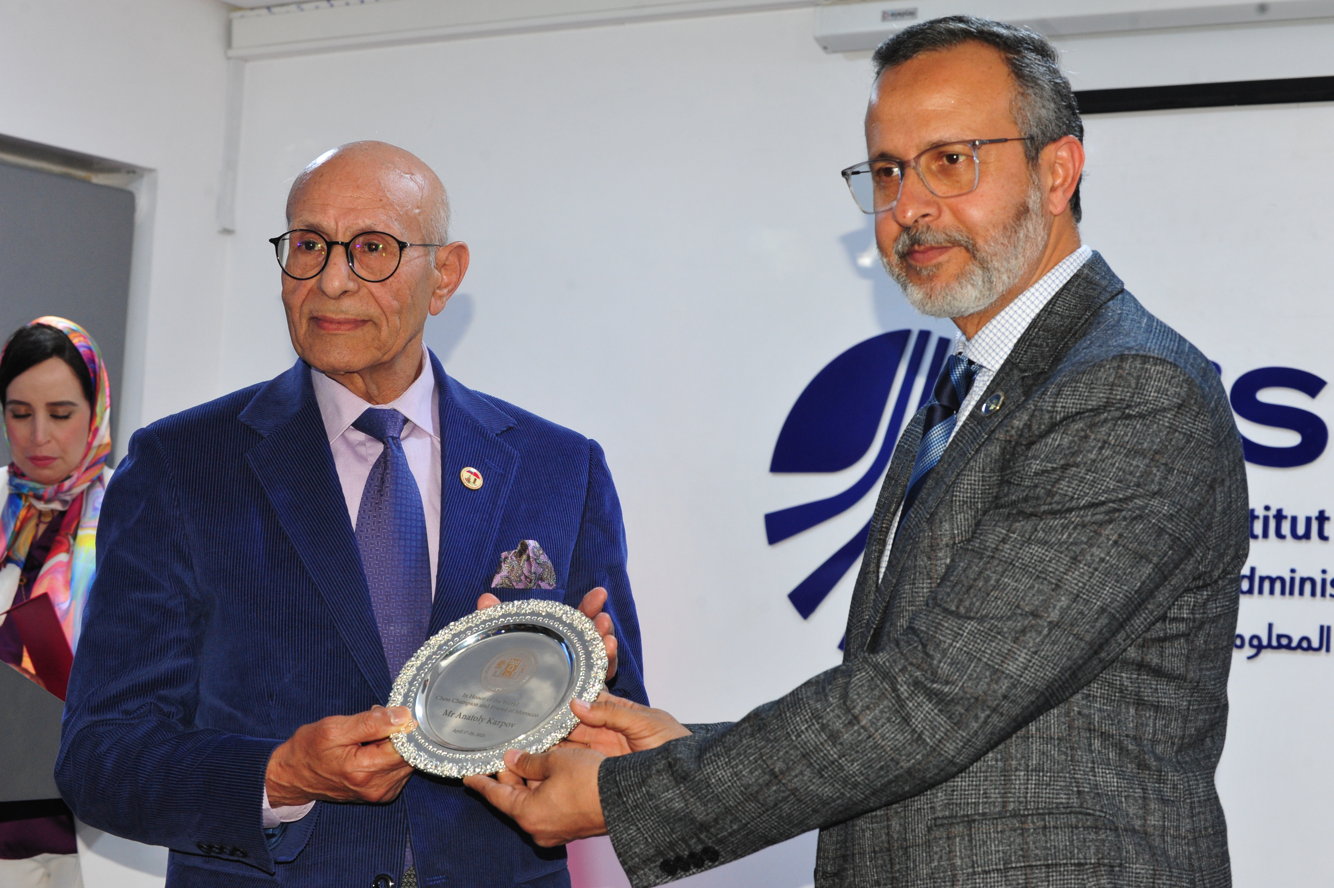 À gauche : Dr Abdellatif Bahraoui, Président de l'Association d'Amitié Maroco-Russe, venu représenter Anatoly Karpov. À droite : Abdellah Laissaoui, président de l'ISMAGI. À gauche : Dr Abdellatif Bahraoui, Président de l'Association d'Amitié Maroco-Russe, venu représenter Anatoly Karpov. À droite : Abdellah Laissaoui, président de l'ISMAGI.