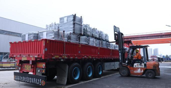 Des ouvriers procèdent au chargement de matériaux de construction destinés à au Maroc.