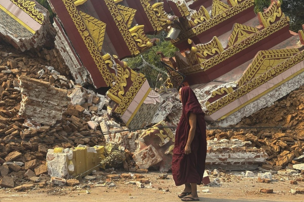 Un moine bouddhiste marche près d'une pagode effondrée après un tremblement de terre à Mandalay, dans le centre du Myanmar, le dimanche 30 mars 2025. Photo AP/Thein Zaw.